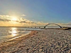 a sandy beach with a bridge in the water at Ferienwohnung auf der Sonneninsel in Fehmarn