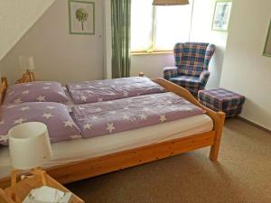 a bedroom with a bed with purple sheets and a chair at Ferienwohnung auf der Sonneninsel in Fehmarn