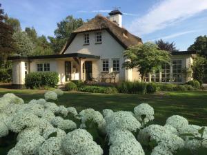 een huis met witte hortensia's ervoor bij Veld en Bosch in Leusden
