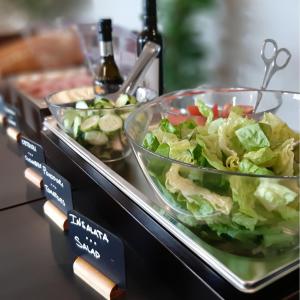 a buffet with a salad in a glass bowl on a table at Fabulous village in Casal Palocco
