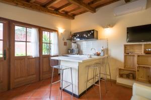 a kitchen with a sink and a counter with stools at B&B Rosso Baccara in Montevettolini