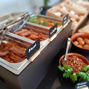 a buffet of food with meats and other foods at Fabulous village in Casal Palocco