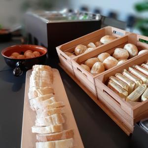 a table with a box of bread and a tray of breadsticks at Fabulous village in Casal Palocco