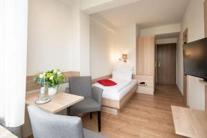um quarto de hotel com uma cama, uma mesa e cadeiras em Gästehaus Sanssouci em Bad Wildungen