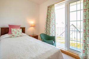 a bedroom with a bed and a large window at Shearwater Self Catering in Union Hall