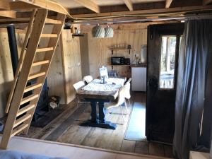une salle à manger avec une table et une échelle dans l'établissement Cabin in the Green - near Amsterdam, à Velsen-Zuid