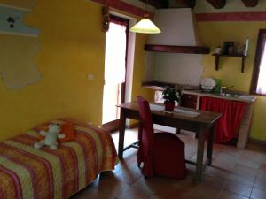 a bedroom with a table and a bed and a kitchen at El Pendola in Fumane