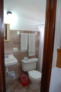 a bathroom with a toilet and a sink with towels at Hotel Alux Cancun in Cancún