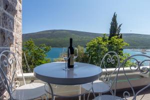 uma mesa com uma garrafa de vinho e dois copos em Riva Residence em Herceg Novi