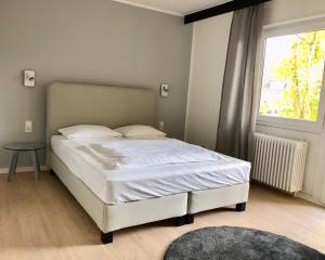1 dormitorio con cama blanca y ventana en City Hotel und City Apartments Centrum, en Kaiserslautern