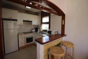 a kitchen with a counter and two stools in it at Apart-rent Casa con piscina Sant Maurici 0191 in Empuriabrava