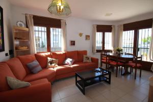 a living room with an orange couch and a table at Apart-rent Casa con piscina Sant Maurici 0191 in Empuriabrava