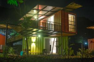 a house with a green facade at night at Avanti Kalagram Hill Top Resort, Mulshi in Kolvan