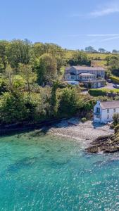 uma vista aérea de uma casa ao lado de uma massa de água em Shearwater Country House Accommodation em Union Hall