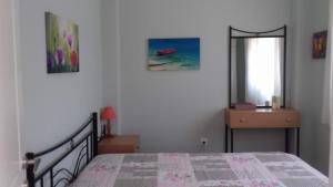a bedroom with a bed and a mirror and a window at Ground beach studio in Nea Potidaea