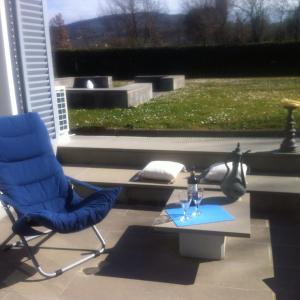 a blue chair and a table with wine glasses on it at Firenze in collina con piscina in Bagno a Ripoli