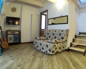 a living room with a couch and stairs and a guitar at Appartamento in centro storico in Ortona