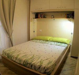 a bed in a bedroom with a green pillow on it at Appartamento in centro storico in Ortona