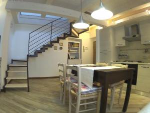kuchnia i jadalnia ze stołem i schodami w obiekcie Appartamento in centro storico w mieście Ortona