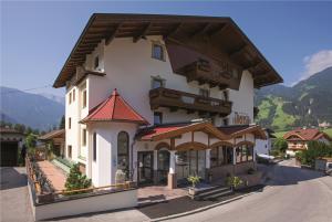 duży biały budynek z czerwonym dachem w obiekcie Hotel Theresia w mieście Ramsau im Zillertal
