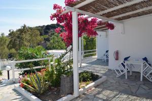 a white house with pink flowers on a patio at Paleochori Studios in Paliochori