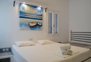 a bedroom with a bed with a painting on the wall at Paleochori Studios in Paliochori