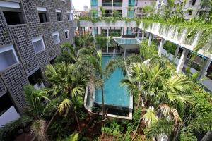 an overhead view of a swimming pool in a building with palm trees at Baitong Hotel & Resort Phnom Penh in Phnom Penh