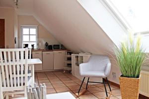 eine Küche mit einem Dachboden mit einem Tisch und Stühlen in der Unterkunft Muschel in Werdum