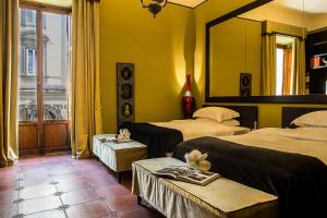 a hotel room with two beds and a mirror at Porcellino Gallery Art Boutique BB in Florence