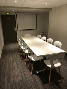 a conference room with a long table and chairs at Hôtel des Halles in Dijon