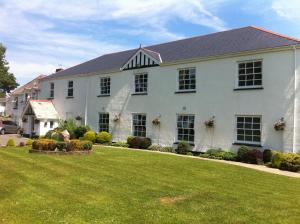 a large white house with a large yard at Beggars Reach Hotel in Pembroke Dock