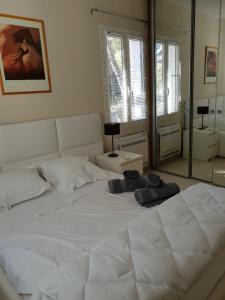 uma cama branca num quarto com um espelho em LOU CIGALOU em Cassis