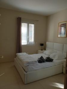 a bedroom with a large white bed with a window at LOU CIGALOU in Cassis