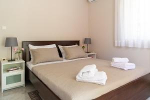 a bedroom with two white towels on a bed at Pepi's house in Artemida