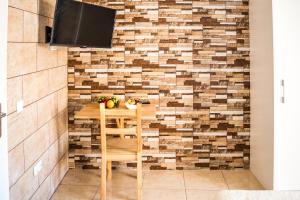 a room with a table and a tv on a brick wall at Hostel Poseidon - HM in El Tablero