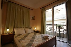 a bedroom with a bed and a window with a balcony at Mirabello Hotel in Heraklio Town