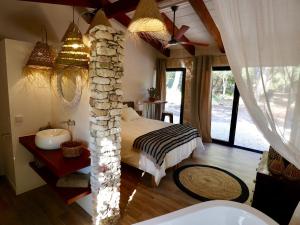 um quarto com uma cama e uma parede de pedra em La Casa Menorca em Ferreries
