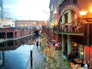 a river in a city with people sitting on a bridge at Contractor Group relocation accommodation Birmingham in Birmingham
