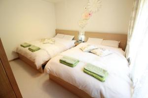 twee bedden in een kamer met groene handdoeken erop bij Hakone Yumoto Condominium Sakura with Hot Spring B-9 #Hs1 in Hakone