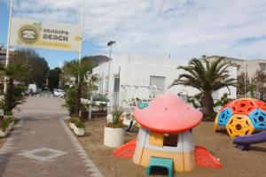 um parque infantil em frente a um edifício com uma placa em Hotel Villa Arlotti em Rimini