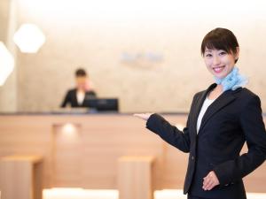 een vrouw in een kamer met een uitgestrekte arm bij Just Inn Premium Toyohashi Station in Toyohashi