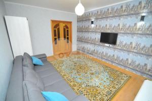 a living room with a gray couch and a television at Large 2-bedroom apartament in the center in Chişinău