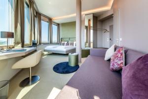 ラドルフツェル・アム・ボーデンゼーにあるaquaTurm Hotel & Energieの紫色のソファとベッド付きのリビングルーム