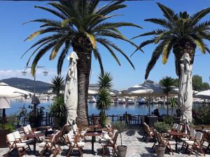 a resort with chairs and palm trees and a body of water at Limanaki Ss View Apartment in Kavala