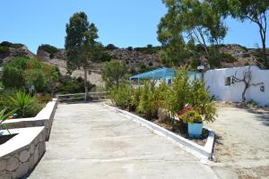 a walkway with flowers and plants in a yard at Paleochori Studios in Paliochori