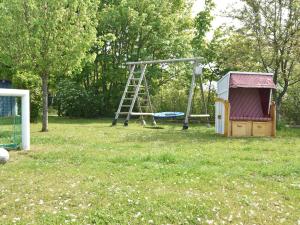 einen Spielplatz mit einer Leiter und einer Schaukel in der Unterkunft Fantastic Apartment in Wiek with Garden in Wiek auf Rügen 