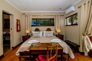 a bedroom with a large bed with a wooden table at Ladera - Vista Self-catering Guesthouse in Paarl +34 photos