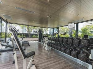 a gym with a row of dumbbells and weights at Maitria Hotel Sukhumvit 18 Bangkok – A Chatrium Collection in Bangkok