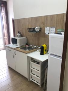 uma cozinha branca com um lavatório e um frigorífico em La Casa Di Fafa em Nápoles