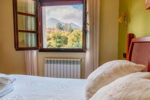 Un dormitorio con una cama y una ventana con vistas. en El Prau la Iglesia Porrua - Llanes, en Porrúa